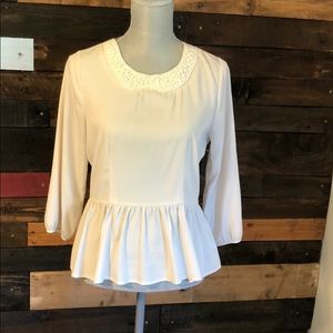 Cream peplum blouse with pearls around neck